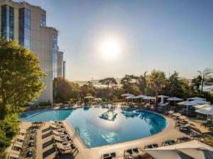 伊斯坦布尔伊斯坦布尔博斯普鲁斯瑞士酒店的一个带躺椅和遮阳伞的大型游泳池