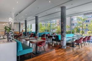 美因河畔法兰克福DoubleTree by Hilton Frankfurt Niederrad的餐厅设有桌椅和窗户。
