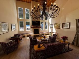 坎波斯杜若尔当Pousada Kaliman Luxo的客厅配有吊灯、沙发和椅子