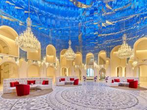 多哈Raffles Doha的大房间设有吊灯和蓝色的天花板