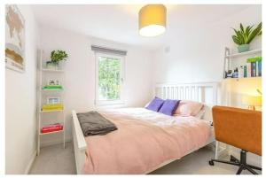 伦敦Stylish, 2 Bed Apartment, Muswell Hill的一间卧室配有一张床、一张书桌和一个窗户。