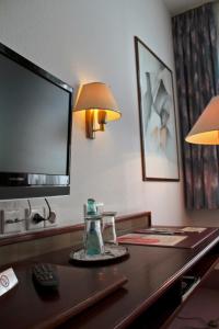 德累斯顿基平酒店的酒店客房配有带电视和茶壶的桌子。