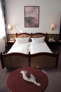 德累斯顿基平酒店的一间卧室配有一张床和一张桌子,上面有蛋糕