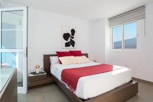 圣克鲁斯-德特内里费Chalet con piscina en Tabaiba by Alterhome的一间卧室配有一张带红色枕头的大床
