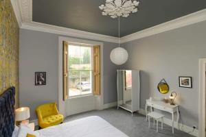 克利夫登Gorgeous Apartment Seconds from Seafront Clevedon的一间卧室配有一张床、一张书桌和一个窗户。