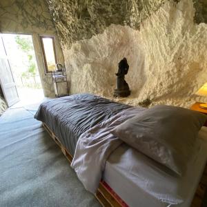 KarangwetanPALEO Stone Age的石墙房间内的一张床位