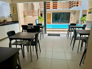 马塞约Hotel Pousada Alagoana的一间带桌椅的餐厅和一个游泳池