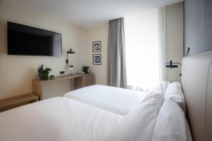 索里亚Hotel & Spa Convento San Francisco的酒店客房设有两张床和一台平面电视。