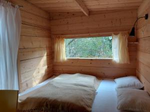 TorestorpGemütliches Tiny House Uggla im Wald am See的小木屋内的卧室,设有窗户