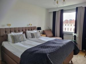 米约尔比Mjölby Stadshotell的一间卧室设有一张大床和一个窗户。