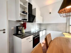 什未林沙尔夫科奇公寓的厨房配有白色橱柜和木桌