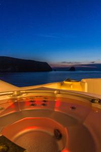 阿波罗尼亚SALT SUITES MILOS的浴缸,晚上可欣赏到海景