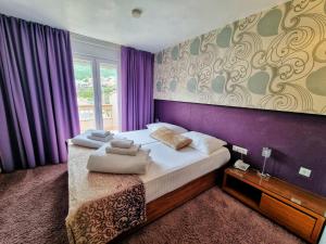 珀德垂那嘉拉斯普利特酒店的一间卧室设有一张紫色墙壁的大床