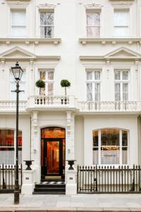伦敦Grand Hotel Bellevue London的白色的建筑,有门和街灯