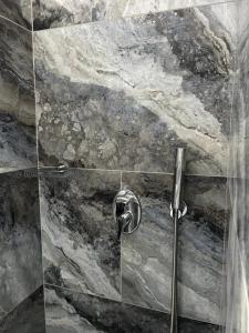 费拉Villa Galaxy Santorini的带淋浴的浴室(带石墙)