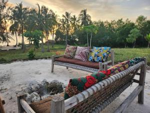 基济姆卡济Sunset Getaway- Villa Makuti的一张沙发,上面有枕头,坐在田野里