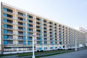 弗吉尼亚海滩巴克莱大厦度假酒店的白色的宽大公寓大楼设有蓝色的窗户