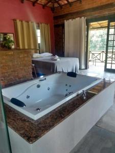 瓦索拉斯Hotel Fazenda Upã Moña的配有两张床的房间,设有大浴缸