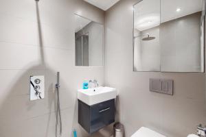 伦敦Modern 3 Bed Apartment in Hampstead的白色的浴室设有水槽和镜子