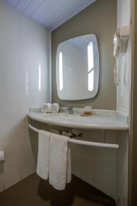 因达亚图巴Rio hotel by Bourbon Indaiatuba Viracopos的浴室配有带镜子的盥洗盆和毛巾
