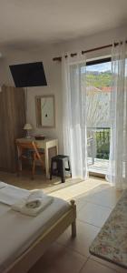 帕拉利昂阿斯特罗Argiropouloi的一间卧室配有一张床、一张桌子和一个窗户。
