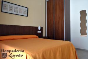 拉卡尔洛塔Hospedería Laredo的一间卧室配有一张带橙色毯子的床