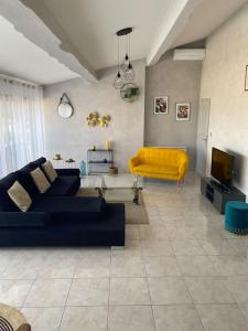Cases-de-PèneAppartement spacieux的客厅配有蓝色的沙发和黄色的椅子