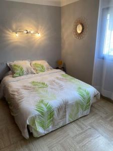 Cases-de-PèneAppartement spacieux的一间卧室配有一张带棕榈叶的白色棉被的床