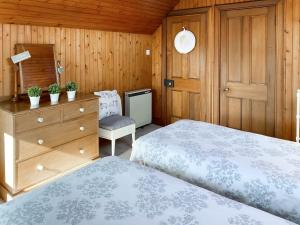 Kilmichael Glassary科南度假屋的一间卧室配有两张床、一个梳妆台和椅子