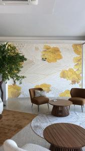 里米尼Hotel Golden的客厅配有椅子和带花卉壁画的墙壁