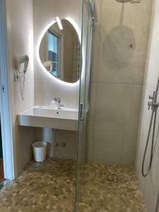 里米尼Hotel Golden的带淋浴、盥洗盆和镜子的浴室