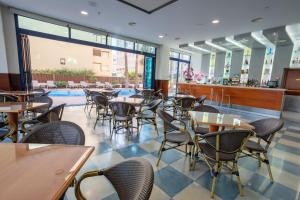 甘迪亚西贝莱斯海滩酒店的一间带桌椅的餐厅和一个游泳池