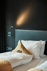 波恩波恩卡梅哈大酒店的一张带白色枕头的床和一盏灯