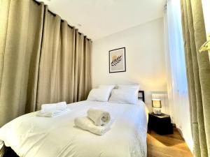 罗莫朗坦Les Logis d'Esmeralda-Des appartements au charme intemporel的一间卧室配有带毛巾的床