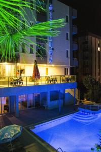 安塔利亚Luna Lara Hotel的夜间设有游泳池的酒店