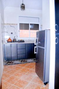 Airport apartment 2的厨房配有不锈钢冰箱和瓷砖地板。