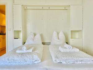 吕贝克Strand Suite的一张白色的床,上面有两个枕头