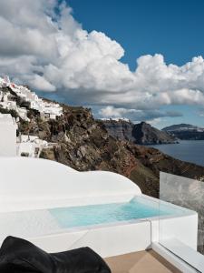 伊亚Olvos Luxury Suites的享有大海和建筑景致的游泳池