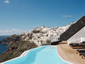 伊亚Olvos Luxury Suites的享有白色建筑山景的游泳池