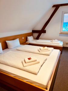 鲁斯特Gästehaus Spoth的配有2张床的客房内配有白色床单和毛巾