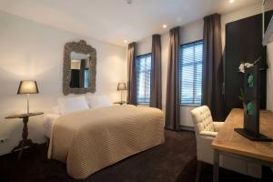 威廉斯塔德Hotel Mauritz的一间卧室配有一张床、一把椅子和镜子