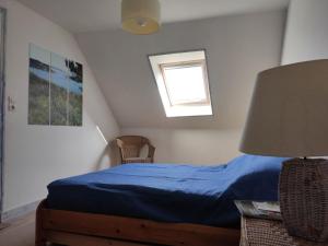 洛克马里亚Maison Locmaria, 3 pièces, 4 personnes - FR-1-418-91的一间卧室设有蓝色的床和窗户。