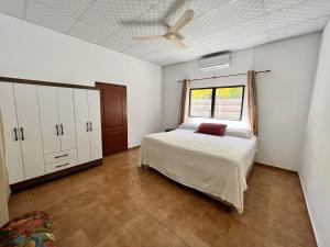洛斯科巴诺斯Beautiful beach house in Los Cobanos El Salvador的一间卧室配有一张床和吊扇