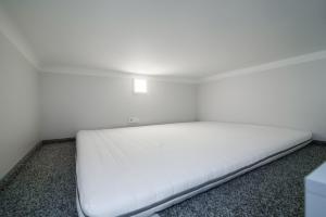 维尔纽斯Cozy Loft / Near Gates of Dawn / Free Netflix的一张位于带白色床垫的房间内的床铺