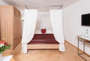 Flörsheim-DalsheimGästehaus & Weingut PETH的一间卧室配有带窗帘的天蓬床