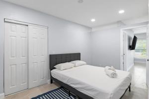 萨尼贝尔Upgraded Ground Floor Residence on Buttonwood Ln w Bikes的一间白色卧室,配有床和电视