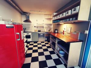 卢塞恩卢塞恩背包客旅舍的一间带红色冰箱和 ⁇ 格地板的厨房