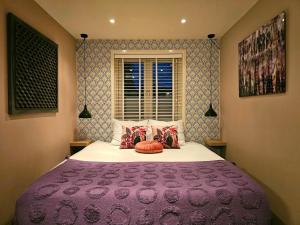 赞德沃特Zandvoort at Home I Free parking & Airco的一间卧室配有一张大床和紫色毯子