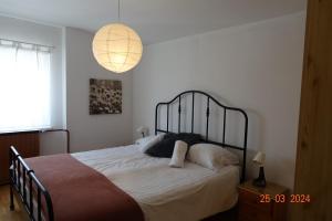 伦达瓦APARTMA LINDAU的一间卧室配有一张带白色床单和一盏灯的床。