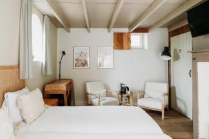 AlemHet Hart Van Alem的一间卧室配有一张床和两把椅子